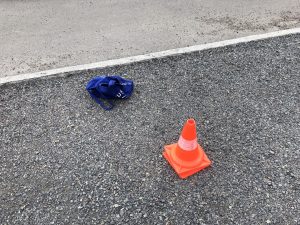 Image shows traffic cone and bag on the ground