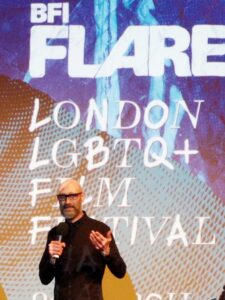 Medium shot of Timothy Smith speaking onstage at the 2018 BFI Flare Film Festival